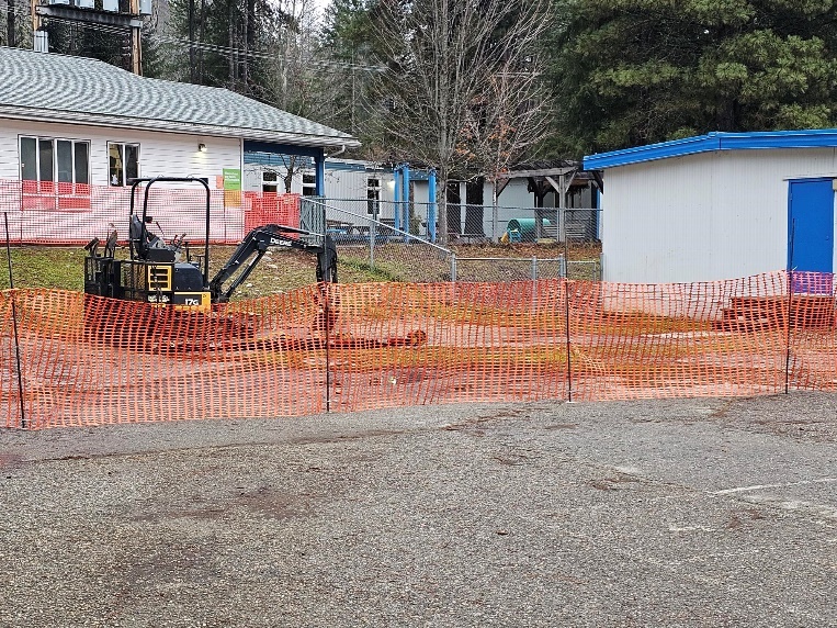 A construction site with a fence and a building</p>
<p>Description automatically generated