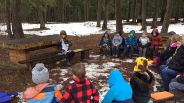 BKE Kindergarten Class engaging in outdoor learning at the outdoor classroom in the forest area of the school. 